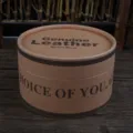Close-up detail view of a cylindrical brown cardboard box for belts with printed English text - Gift Box