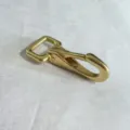 Gedetailleerd overzicht van gouden metalen karabijnhaak, stevig accessoire voor tassen. - Gouden Gesp