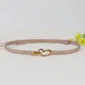 Detail view of a genuine leather women belt featuring a stylish gold tone heart buckle design. - Khaki
