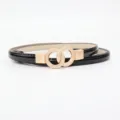 Cintura sottile in vera vernice nera da donna con fibbia dorata a doppio anello intrecciato. - Nero