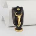 Close-up detail of black genuine leather belt key holder with brass metal hook and D-ring. - Black