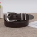 Detail view of a women's dark brown leather belt featuring vintage silver metal buckle and tip. - Coffee