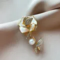 Exquisite rhinestone rose brooch detail, elegant gold metal finish with crystal pearl design. - Gold