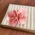 Elegant large pink orchid flower hair clip with pearl center displayed on velvet tray - Blush