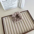 Chouchou en peluche de couleur thé au lait présenté sur un plateau à bijoux beige élégant - Khaki