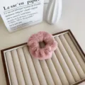 Chouchou élégant en fausse fourrure rose présenté sur un présentoir à bijoux pro - Rose Poudré