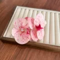 Elegant large pink orchid hair clip with faux pearls on a beige jewelry display. - Pink