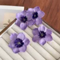 Élégantes pinces à cheveux fleurs en tissu violet sur un plateau de bijoux beige. - Ensemble de 4 Pièces / Lot de 4 / Violet
