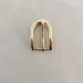 Gold metal horseshoe pin buckle detail closeup, replacement hardware for belts and bags. - Gold