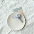 Grande pince à cheveux en tissu bleu clair avec texture plissée pour coiffure femme - Bleu clair