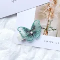 Sweet mint green embroidered mesh butterfly hair clip with a pearl center detail - Cyan