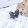 Elegant purple embroidered butterfly hair clip with central pearl on a white background - Deep purple
