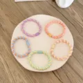 Lot de cinq élastiques à cheveux torsadés colorés aux tons pastels sur une assiette - 5 Pièces / Bloc de Couleur Fileté