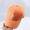 Orange baseball cap detail showing embroidered letter P on crown and curved brim for casual wear. - Adjustable / Orange Baseball Cap with Embroidered Letter P