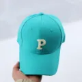 Turquoise baseball cap detail showcasing the front white embroidered letter P and neat stitching. - Adjustable / Blue Baseball Cap with Embroidered Letter P