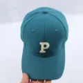 Baseball cap detail close-up showing white embroidered letter P on teal fabric surface. - Adjustable / Dark Blue Baseball Cap with Embroidered Letter P
