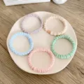 Set of five high-elastic macaron-colored twist hair scrunchies on a plate - Puckered Solid Color Style