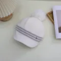 Close-up detail of the Japanese style striped knit beanie with fluffy pom-pom for women. - Adjustable / White