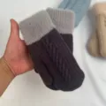 Primo piano di comode moffole invernali lavorate a maglia con polsini in peluche e trecce. - Trecce a doppio strato - nero