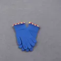 Close-up of winter warm knitted gloves with blue body and colorful pom-pom cuffs detail. - One Size / Blue