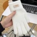 Detail shot of women's thick winter warm knitted gloves, soft and comfortable fabric. - White