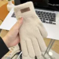Close-up detail of women winter warm beige knitted gloves, soft wool five-finger design. - Khaki