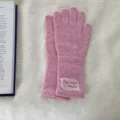 Pink knit gloves detail view showing soft wool texture and delicate white lace label decoration. - One Size / Rose Red