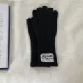 Detailed view of black knitted long touchscreen gloves featuring delicate lace patch decoration. - One Size / Black