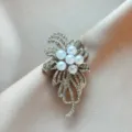 Close-up detail of exquisite alloy rhinestone pearl flower brooch, elegant clothing accessory. - Floral Brooch (972) / Gold