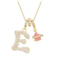 Macro detail of gold letter E pendant with pink planet charm and white zircon. - Letter E