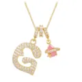 Detailed close-up of gold necklace featuring a zircon heart letter G and pink star pendant - Letter G