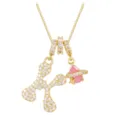 Close-up of gold-plated pendant featuring letter K with pink stone and white zircons - Letter K