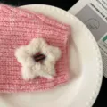 Pince à cheveux étoile en peluche blanc crème sur un fond en tricot rose texturé - Abricot