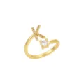 Détail d'une bague ouverte dorée avec l'initiale K sertie et une pierre claire - Lettre K