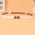 Women's white thin belt detail view showing the vintage metallic knot buckle and clean leather finish. - White