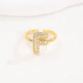 Gedetailleerde detailopname van een gouden ballonletter F ring met fonkelende steentjes - Letter F Stijl