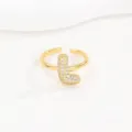 Detailopname van een vergulde open ring met kristal ingelegde ballonletter L goud - Letter L Stijl