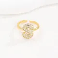 Close-up van een goudkleurige ring met de letter S en heldere zirkonia-stenen - Letter S Stijl