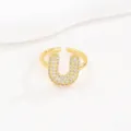 Detailweergave van een goudkleurige bubble letter U ring met pave-gezette zirkoon - Letter U Stijl