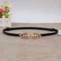 Dettagli della sottile cintura in pelle nera da donna con fibbia decorativa a foglia di perla. - Nero