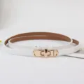 Detailopname van een witte smalle lederen riem met een elegante gouden roterende metalen gesp. - Wit