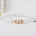 Sottile cintura in pelle bianca con fibbia di chiusura in metallo dorato, dettaglio elegante. - Bianco