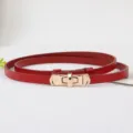 Close-up van rode smalle lederen riem met gouden roterende gesp detail voor jurken. - Rood