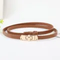 Smalle bruine lederen damesriem con gouden metalen gesp, stijlvol minimalistisch accessoire voor jurk. - Karamel