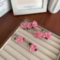 Esthetische handgemaakte roze stoffen camelia haarspelden op een sieradendisplay - Roze Sieradenset