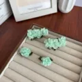 Elegante set mintgroene camelia haarspelden op een luxe juwelendisplay dienblad. - Muntgroen Set