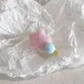 Süße rosa plüschige Stern-Haarklammer mit blauem Bommel auf strukturiertem Hintergrund - Blauer Bommel