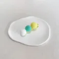 Barrette à cheveux mignonne avec pompons en peluche colorés sur un plat en céramique - Trois Jaunes