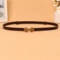 Detailed view of women's thin dark brown leather waist belt with vintage gold buckle. - Coffee