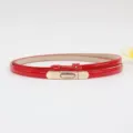 Cintura sottile in pelle verniciata rossa con fibbia metallica dorata, dettaglio elegante. - Rosso